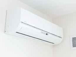 白いシンプルなエアコンが設置された居室の壁は白く、汚れなどもない。エアコンは稼働していない状態。