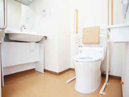 背もたれや手すりがついた便座が設置された広いトイレには車いす対応の手洗い場あり、きれいにされている。