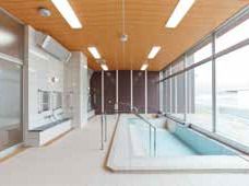 大きな広い浴槽が設置された広い浴室の一面が窓となっていてとても明るい。シャワースペースもあり、手すりも設置されている。