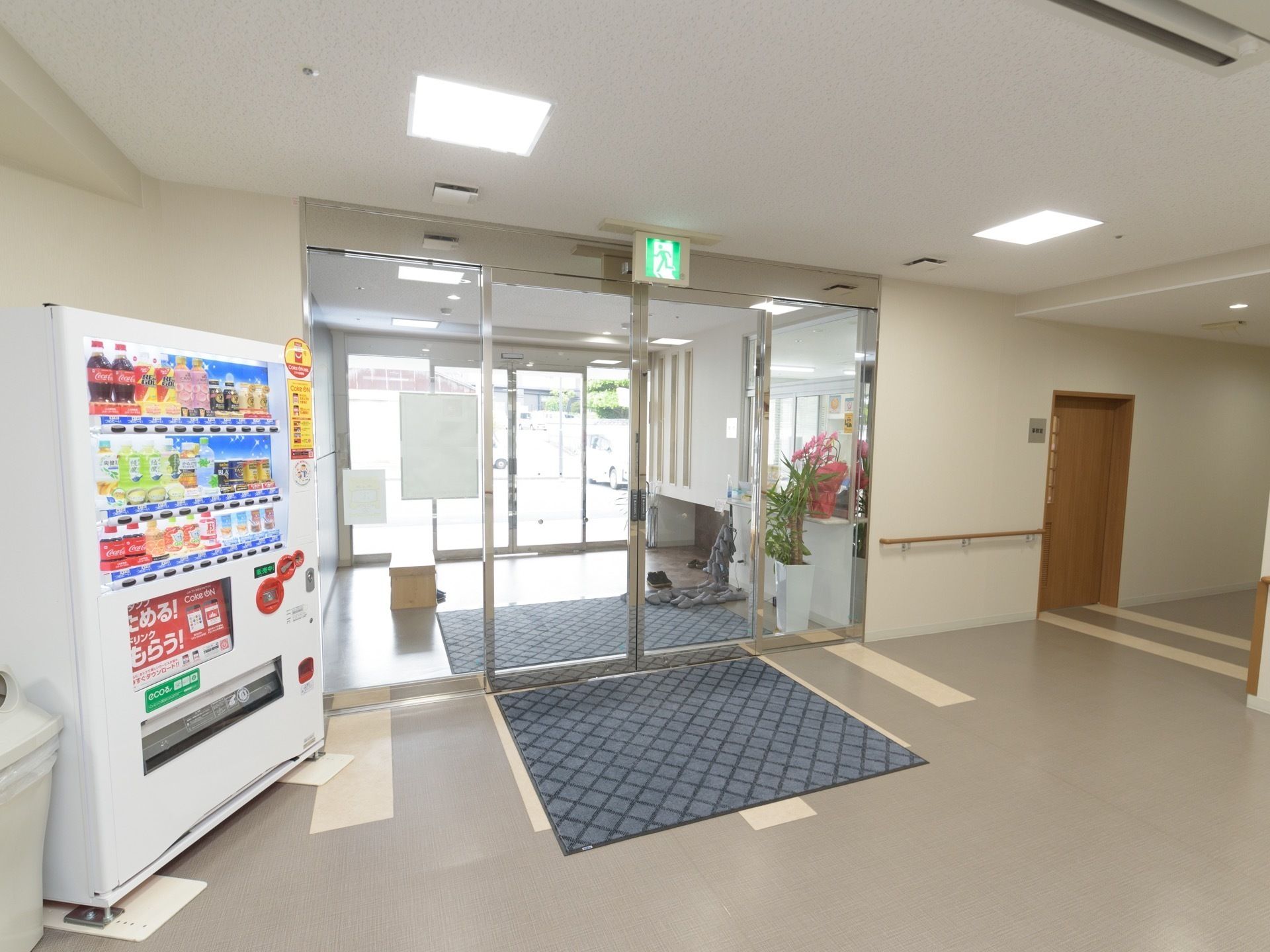 自販機が設置され大きなガラスドアの付いたバリアフリー設計の玄関