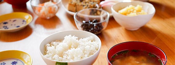 ご飯と味噌汁、蒸しじゃがいも、黒豆などの料理