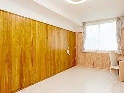 広めの居室内の写真。木目調の壁が印象的な部屋の様子