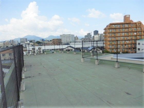屋上は広く黒いフェンスに囲まれ、周辺のビルを見渡すことができる。