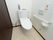 白を基調とした、明るく清潔感のある個室トイレである。便器の上には、消臭剤やウェットシートが用意されている。