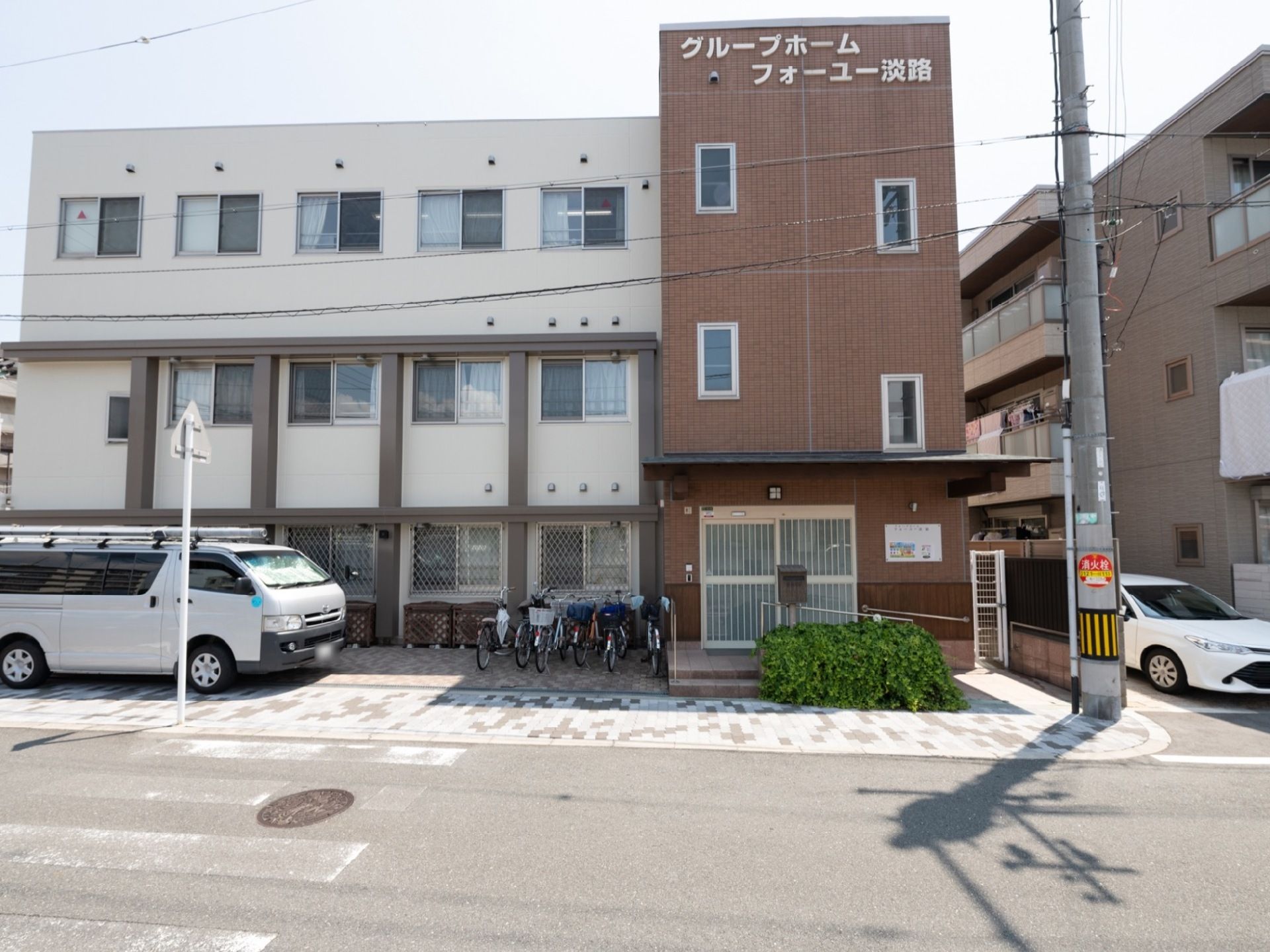 施設の建物はベージュとブラウンの３階建ての建物である。建物の前には自転車を置けるスペースがあり便利である。