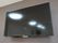 ベージュ色の壁に設置された黒いテレビ