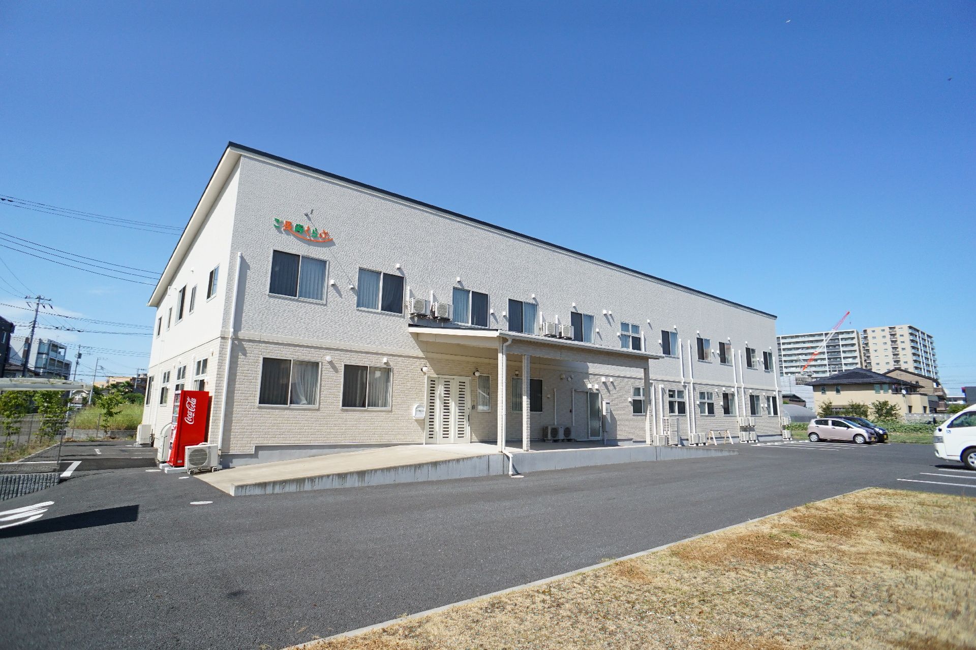 雲一つない青空の下にある２階建ての白い建物