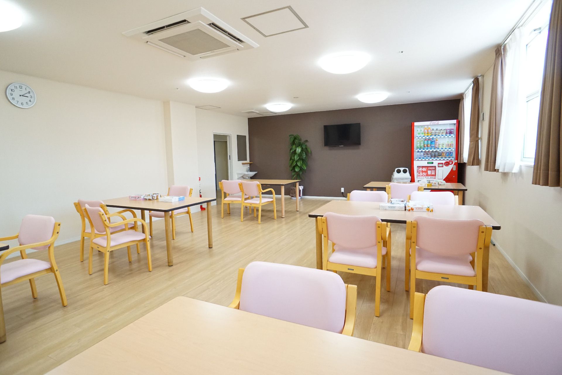白い壁の部屋に置かれたたくさんの椅子と机