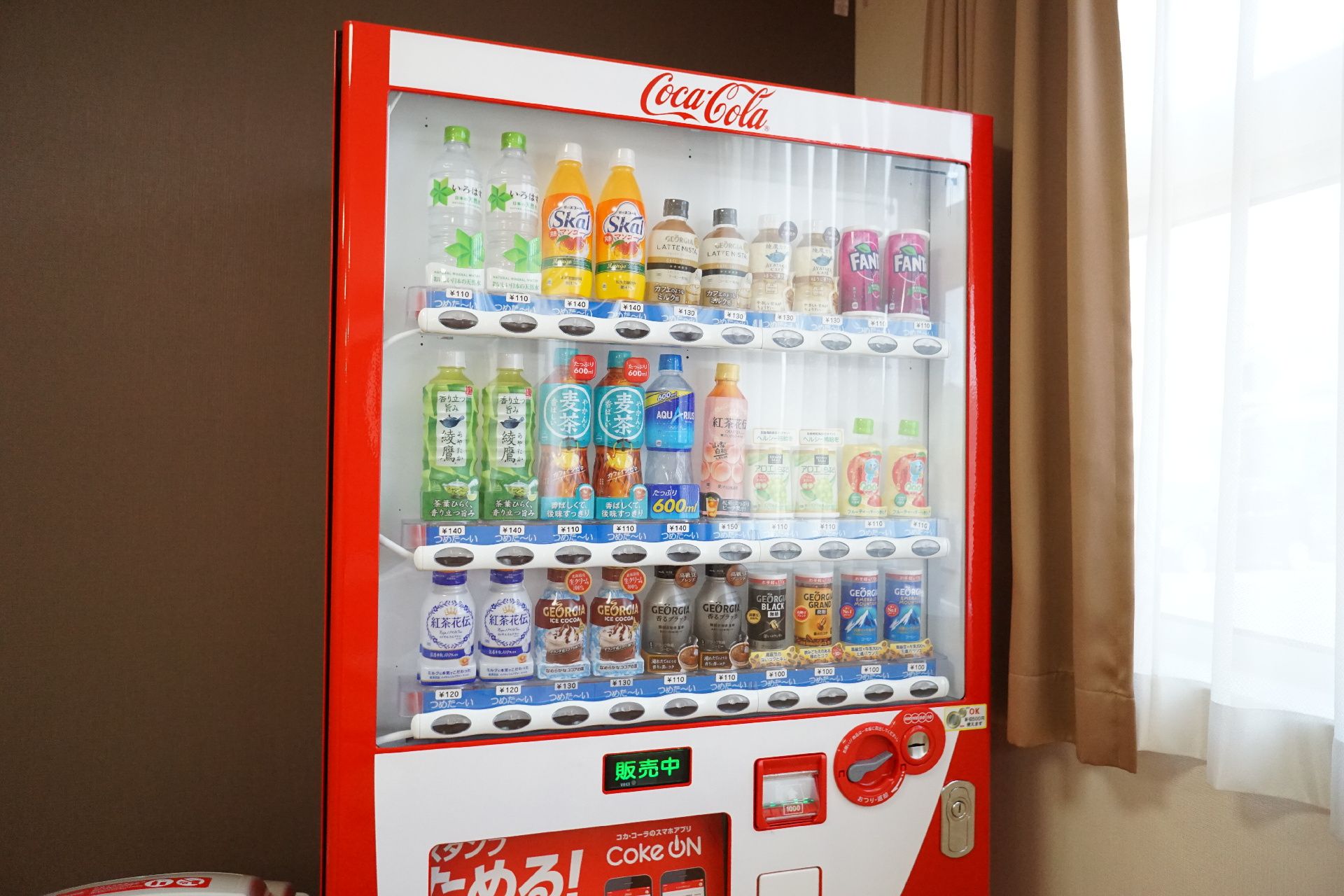 茶色い壁に置かれた赤い自販機