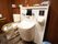 木目調の壁に配置された手すりに囲まれたトイレの手前にあるオストメイトパック