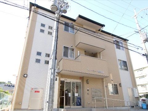 玄関へ手すり付きのスロープが完備された３階建ての施設外観