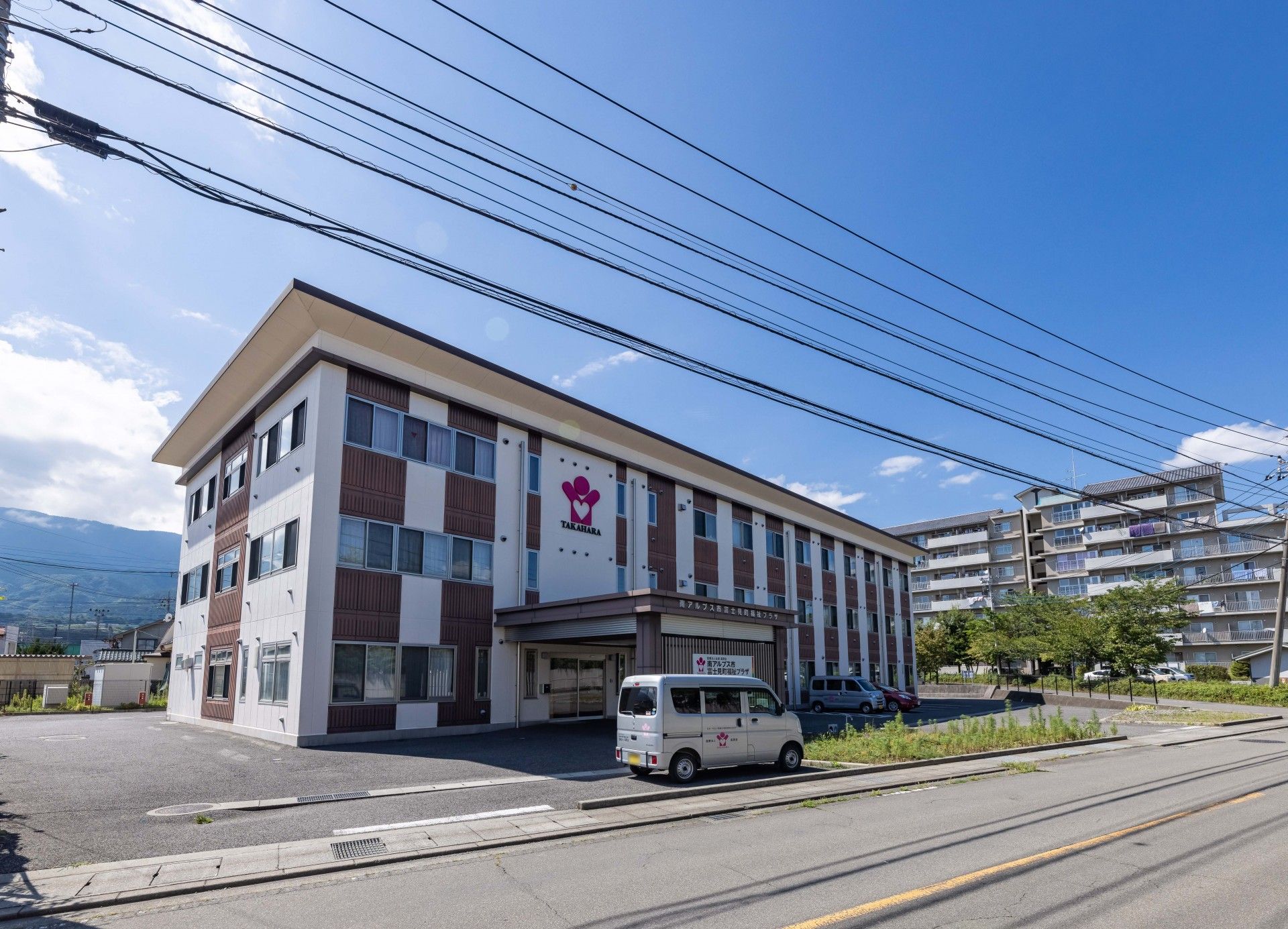 白と茶色の格子柄の3階建て建物
