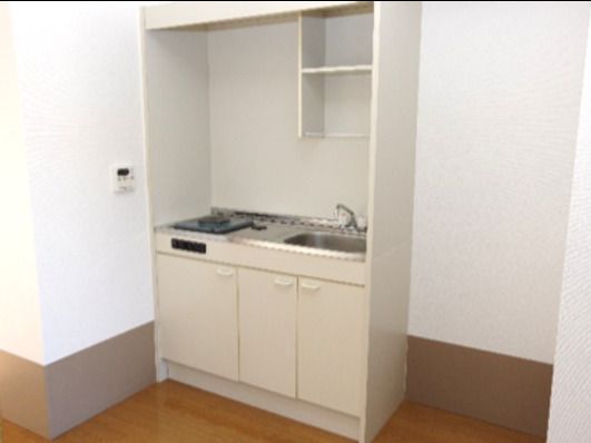 ミニキッチンが付いた居室。シンクの上にはオープンタイプの棚があり、流し下にも収納がある。