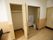 居室の入口の近くに、作り付けの収納と、トイレが備え付けられているのが見える。入口とトイレの扉は引き戸となっている。