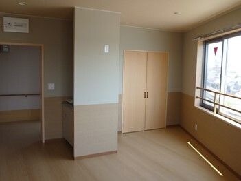 備え付けの収納スペースがあるフローリングの部屋には窓があり、カーテンはない。家具などは置かれていない。