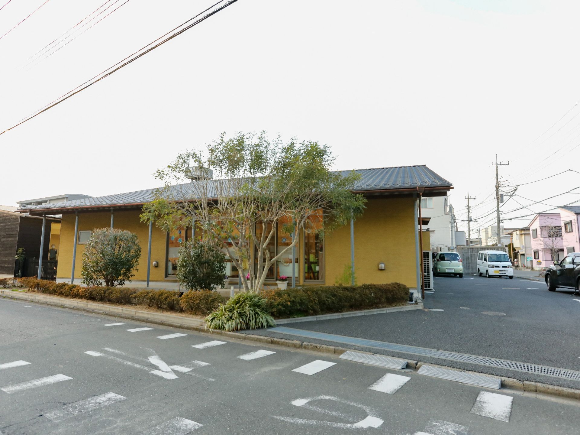 駐車場から撮影した２階建ての介護施設の外観