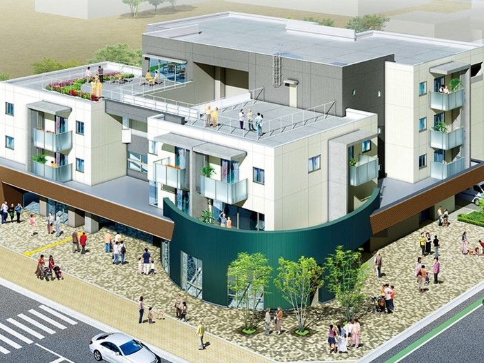 ４階建ての白い建物には屋上やベランダも付き、建物の周辺にはたくさんの人の行き来がある。