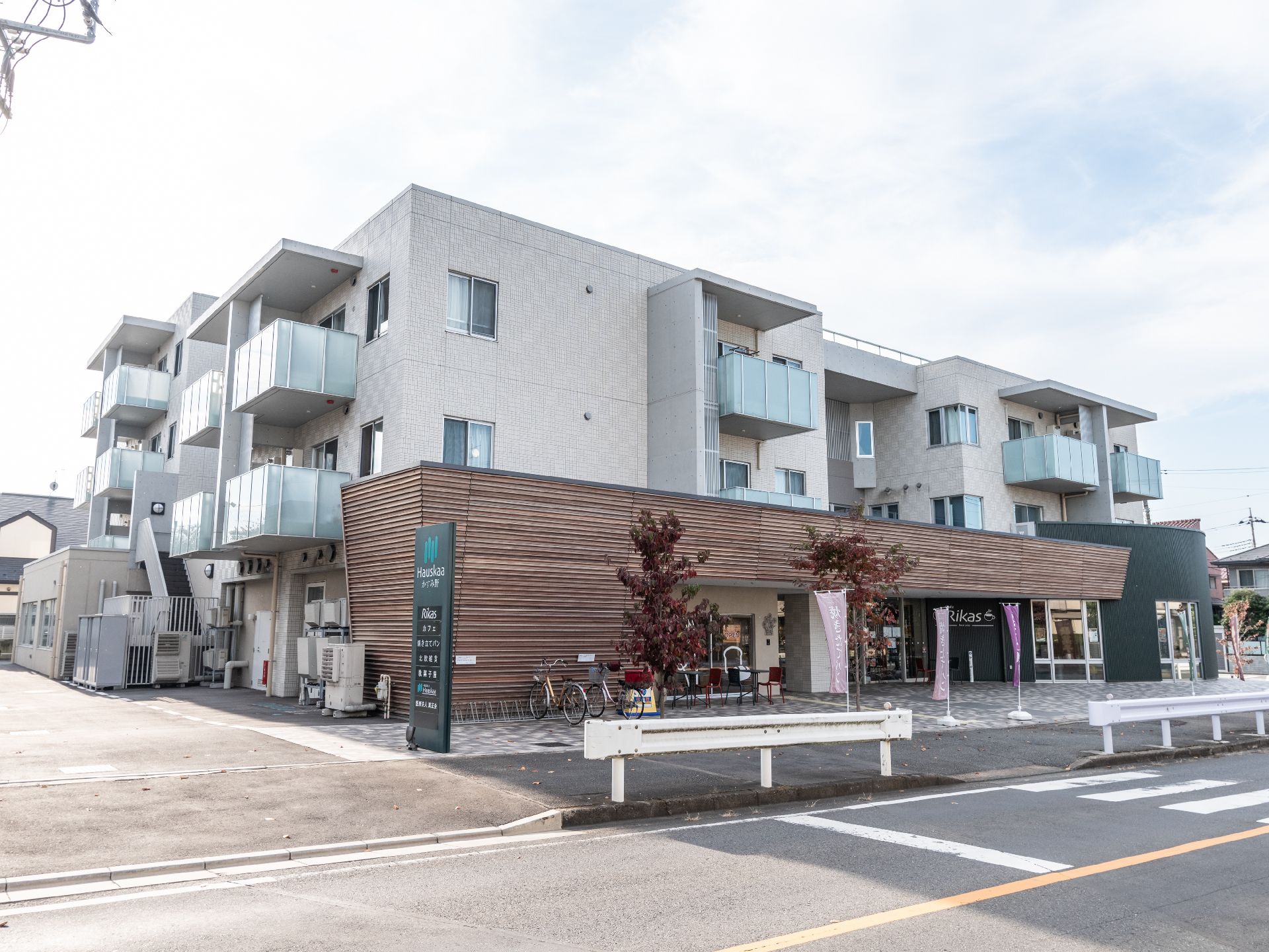デザイン性のある形状を持ち、施設の名称が記載されている看板が設置されている施設の外観