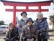 初詣で言った神社の鳥居の前での集合写真。ジャケットや帽子をかぶった4名の入居者。