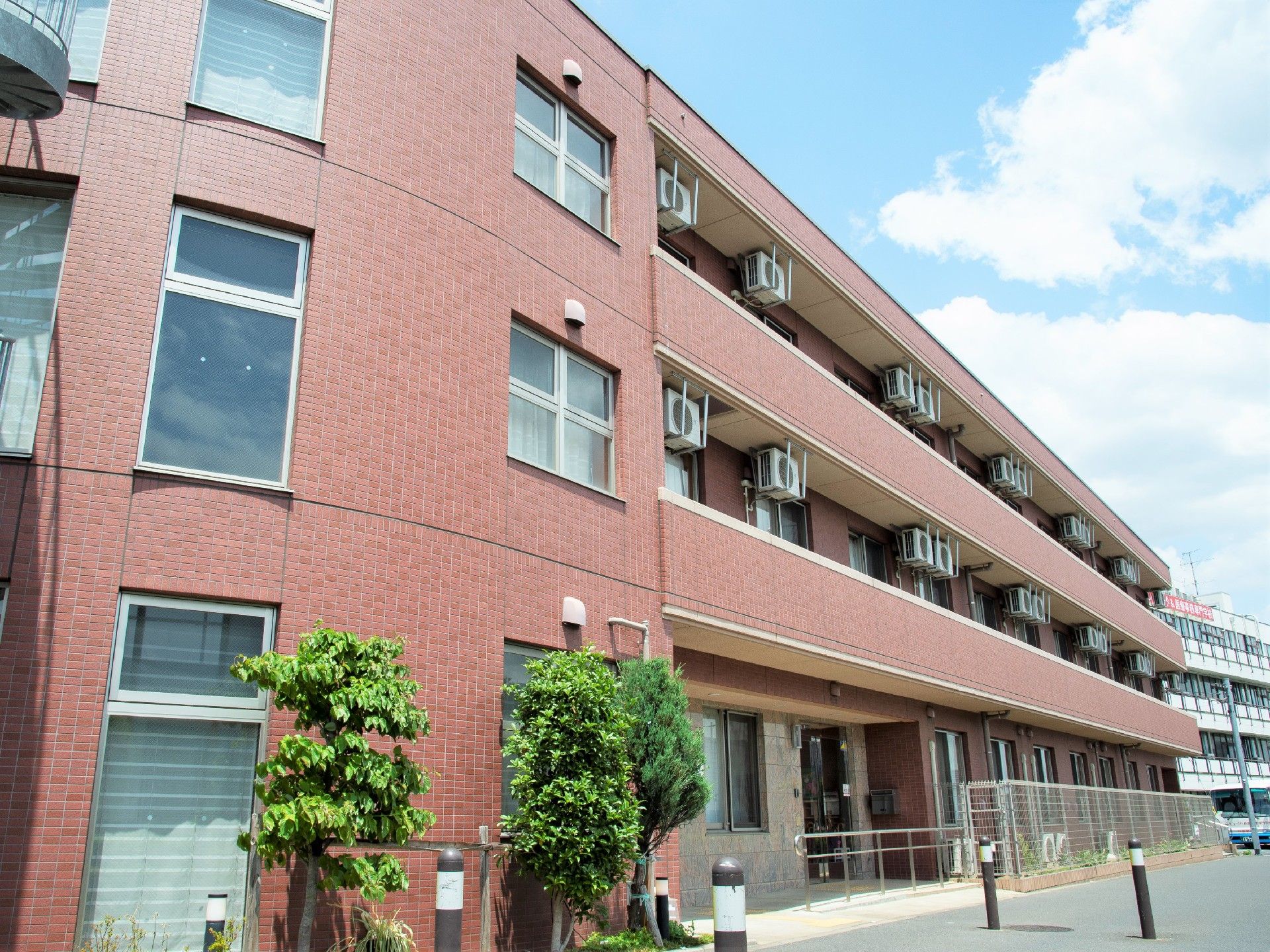 R形に湾曲したデザインの建物。外側に非常階段が付いている施設の外観写真