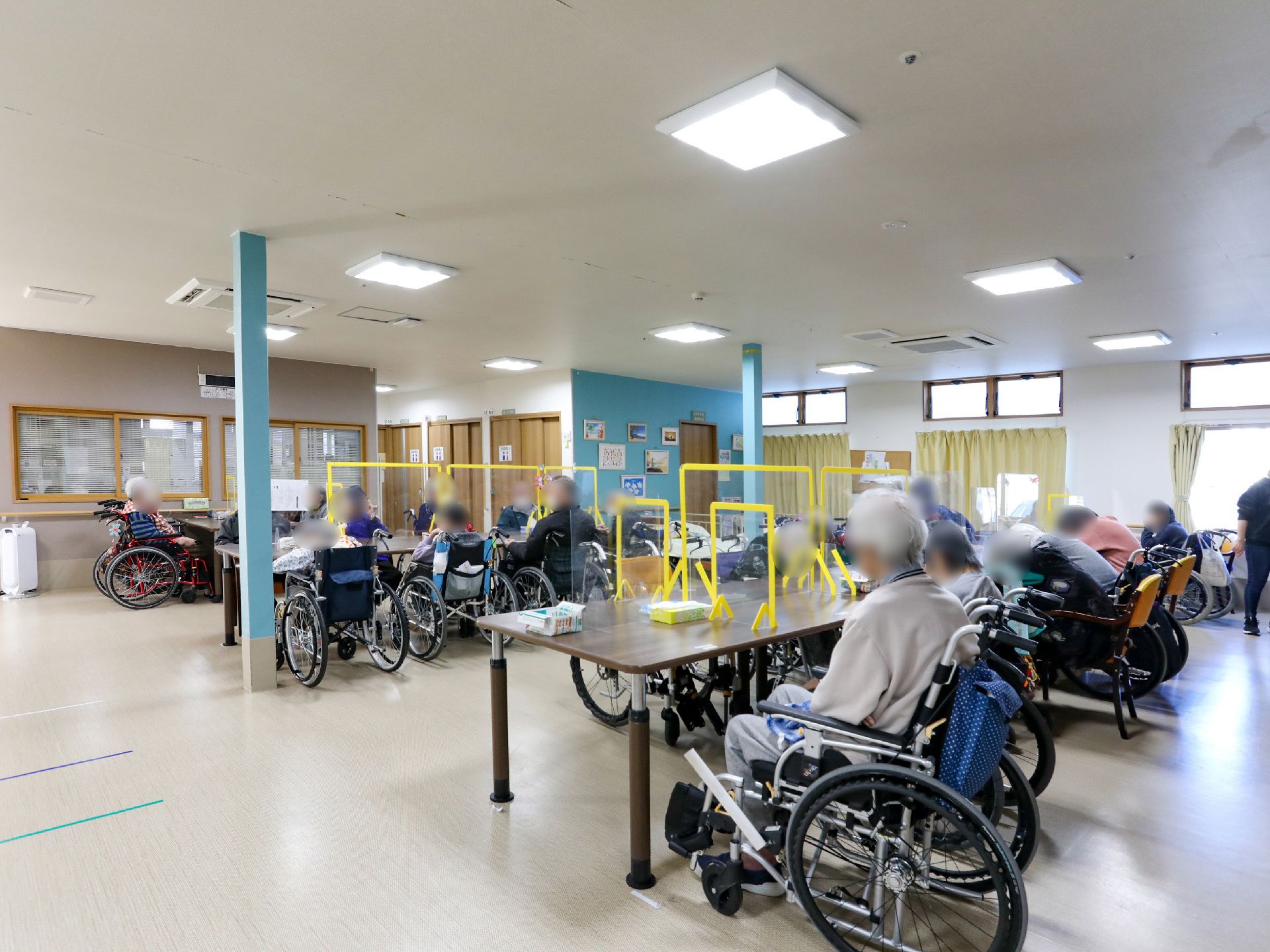 椅子と仕切り板がついているテーブルが設置された共有スペース