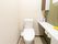 共有のトイレは白い内装で、明るく清潔感がある。片方の壁には棚があり、備品を収納できるようになっている。