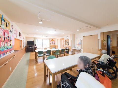 光が差し込む大きな窓のそばにテレビが設置された共有スペース