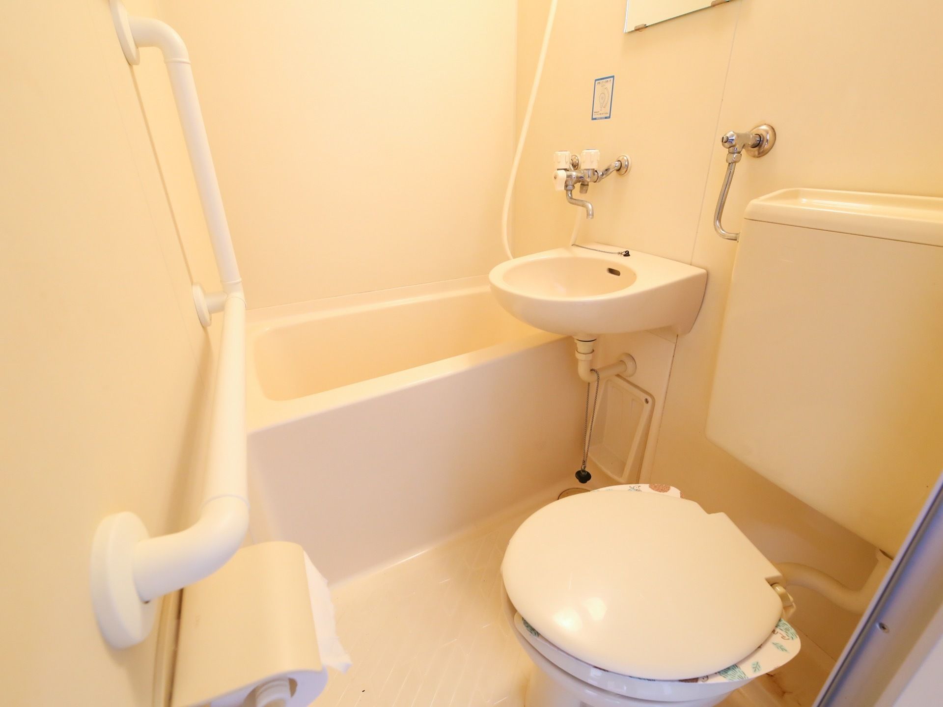 浴室とトイレが一体型となっている。手洗い場が浴槽のそばに設置され、壁には手すりが取り付けられている。