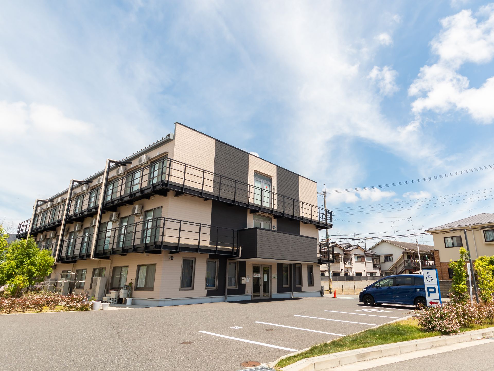 ３階建てで、茶色の落ち着いた色合いが特徴の施設の外観