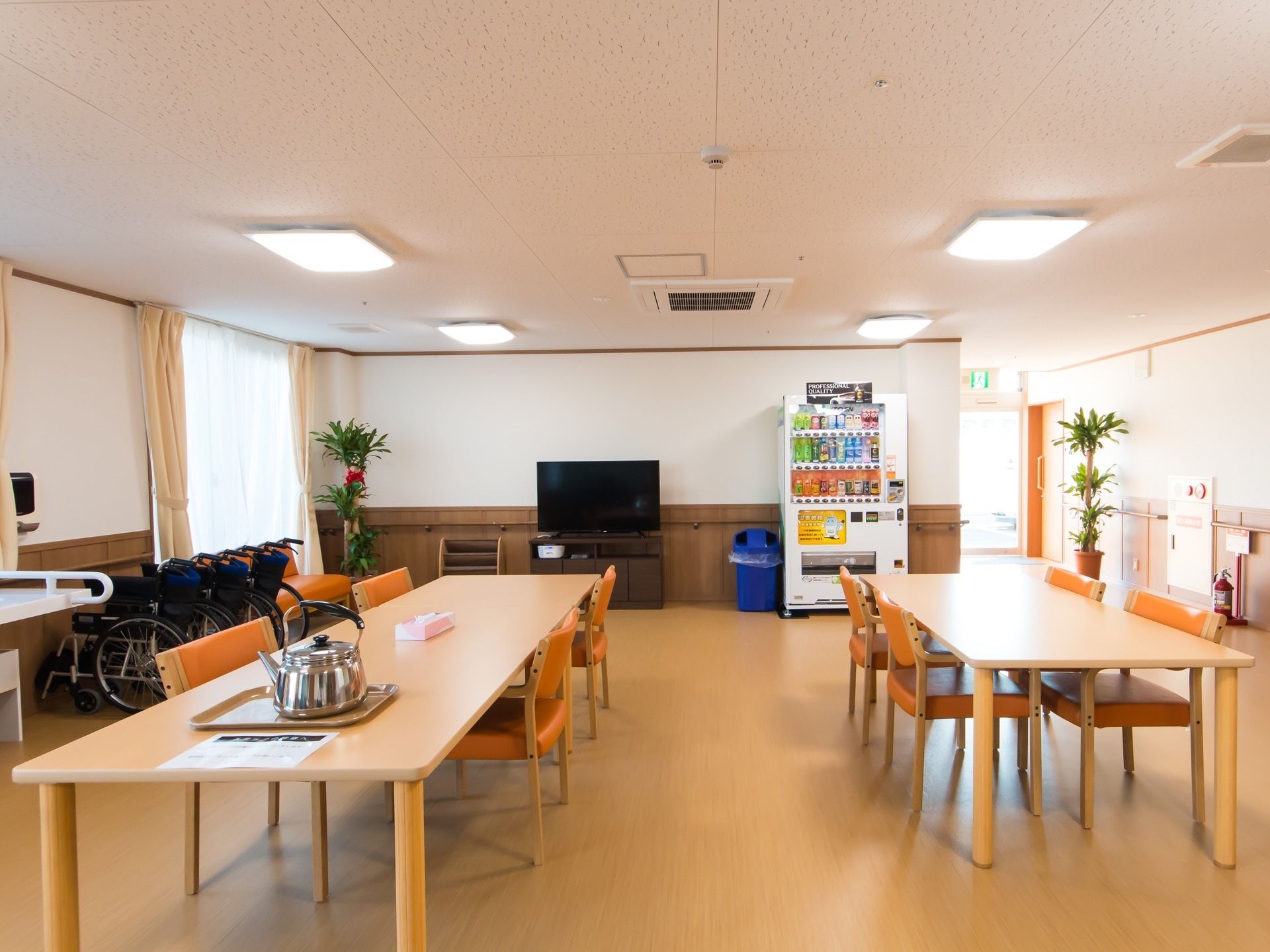 食堂のテーブルは十分間隔を空けて設置されている。何台かの車椅子が折りたたまれて、壁際に並べて置かれている。
