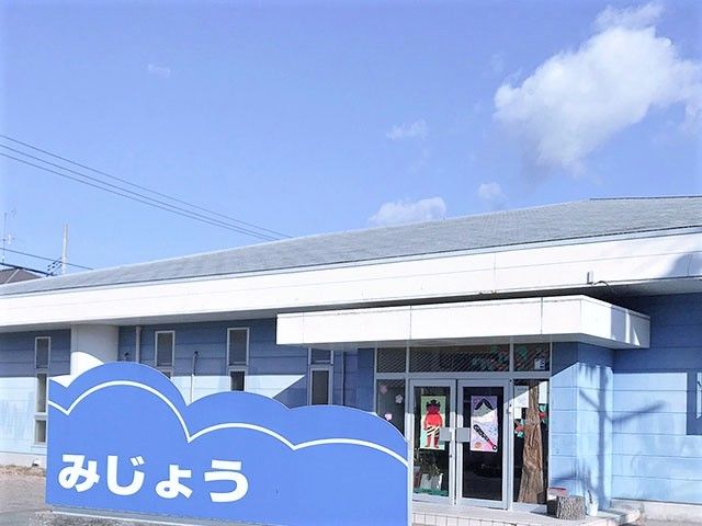 ブルー系でまとめられた平屋建ての建物。玄関の前には大きな青い看板もある。