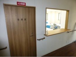 受付はオープンな雰囲気で中に机やいすがあり、受付の横には事務室がある。