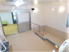 広い脱衣所が奥にあり、手前には広い洗い場と浴槽がある。きれいに掃除がされている。