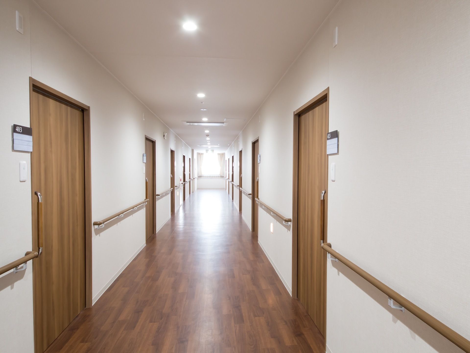 落ち着いた色合いの廊下である。通路には手すりが備えつけられている。各部屋の扉はスライド式になっている。