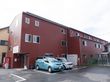 ブラウン系の建物は横に長く、3階建てで、玄関の上にはホーム名が書かれた看板が飾られている。