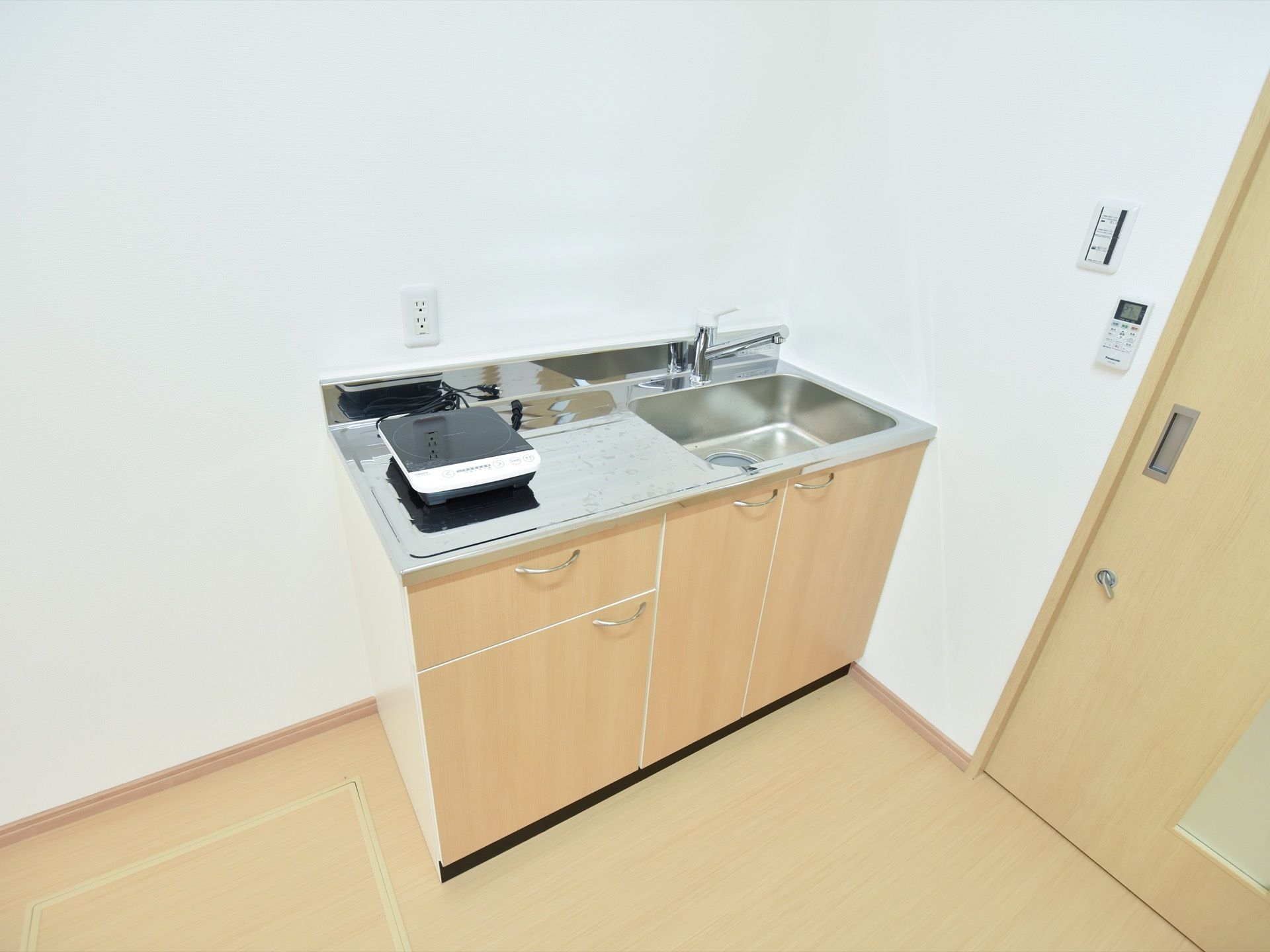 居室のキッチンには収納が多くあるので、調理器具などを整頓して収められる。コンロはIHヒーターで、安全に利用できるように配慮されている。