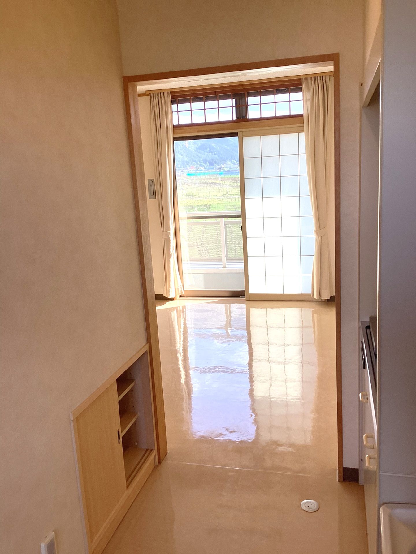 ブラウン系の建物は重厚感があり、自動ドアが設置されている。大きな車寄せが付き、玄関周りには影ができている。