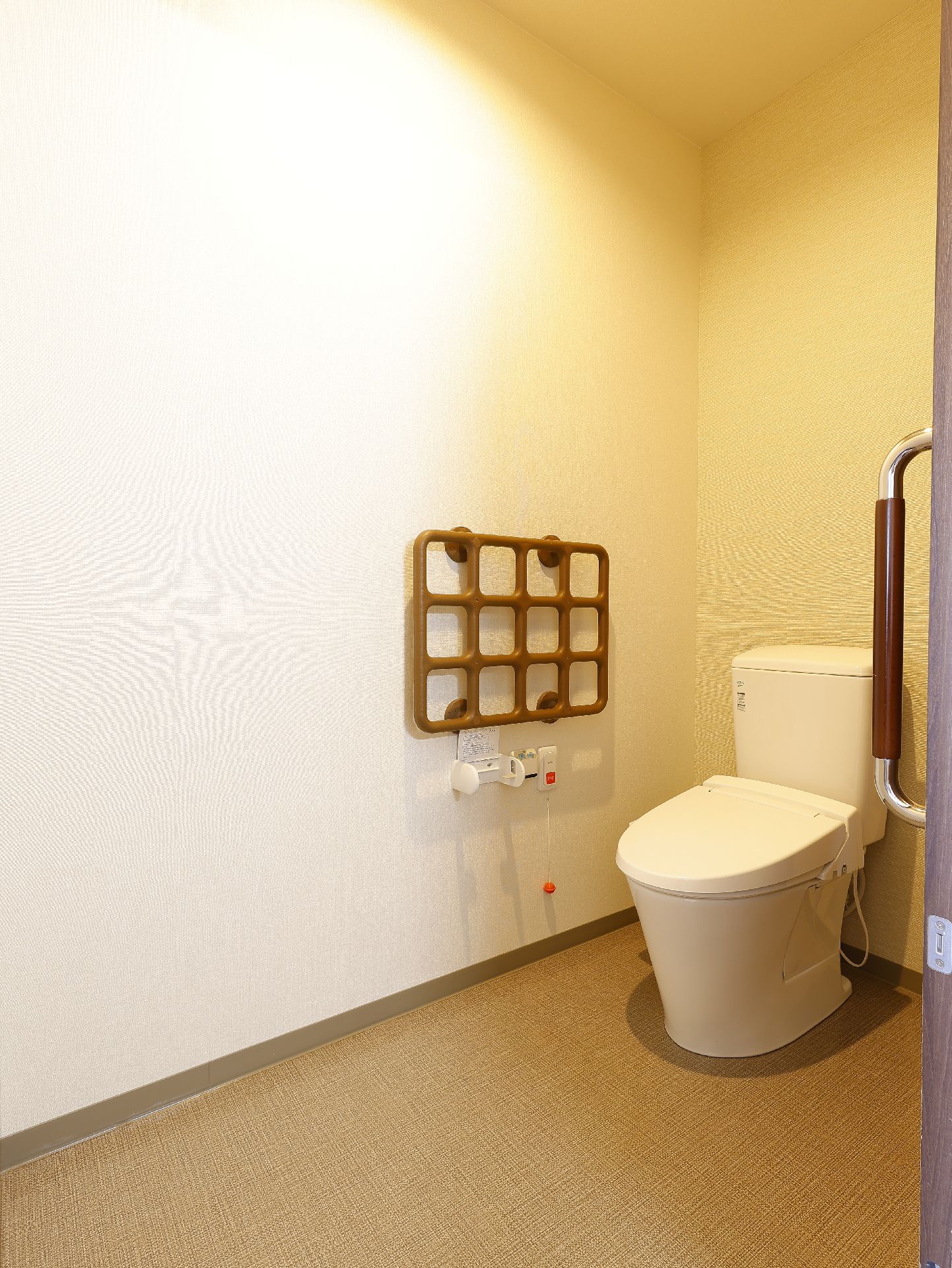 手すりが設置され、床に段差がほとんどない居室にあるトイレ