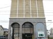 施設は、閑静な住宅地に位置している。施設の目の前を道路が走っていて、外壁には施設名が大きく記されている。