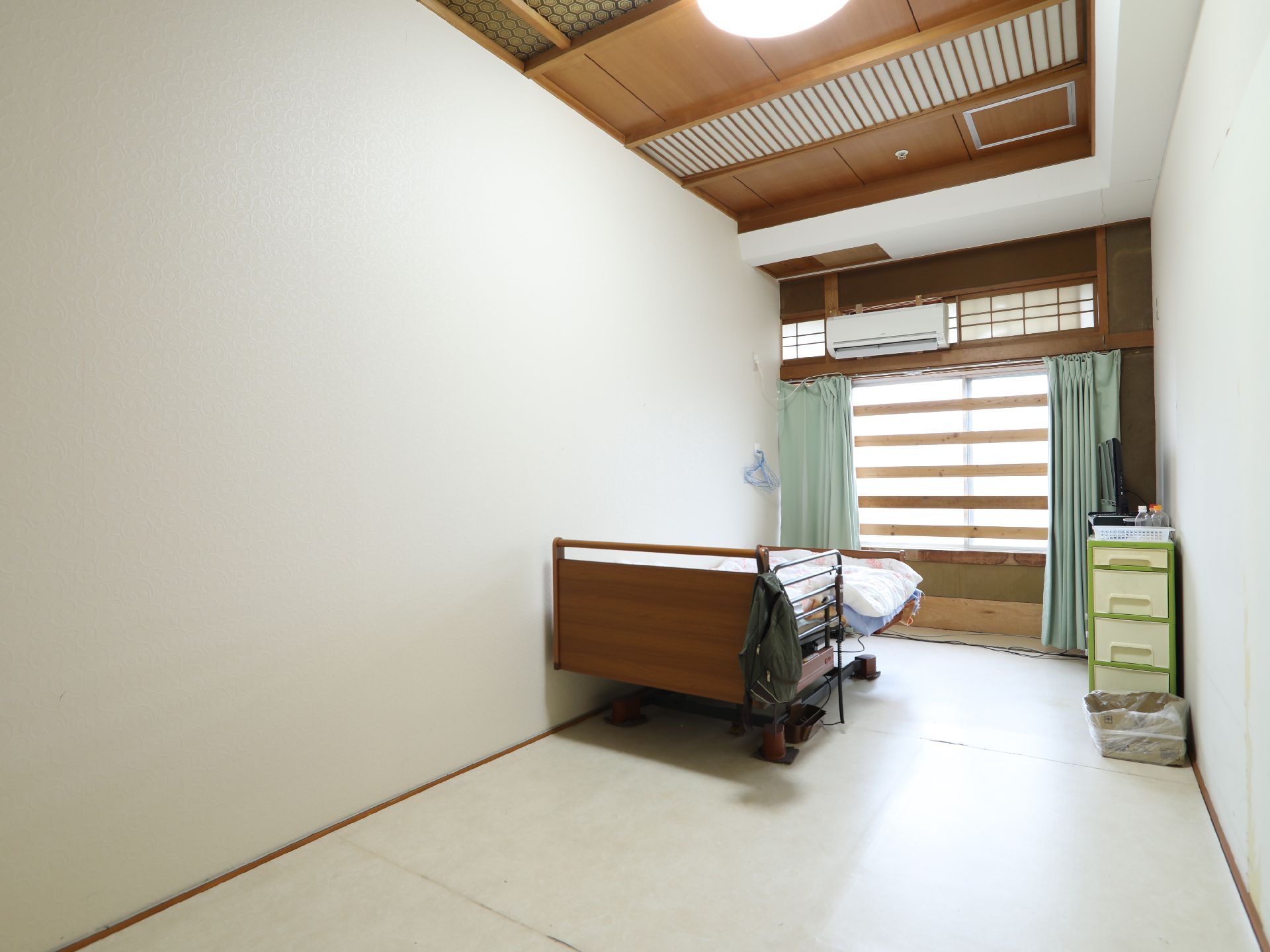 木材を使用した和風調の天井に、窓の上を和室の鴨居と欄間風に造っている居室
