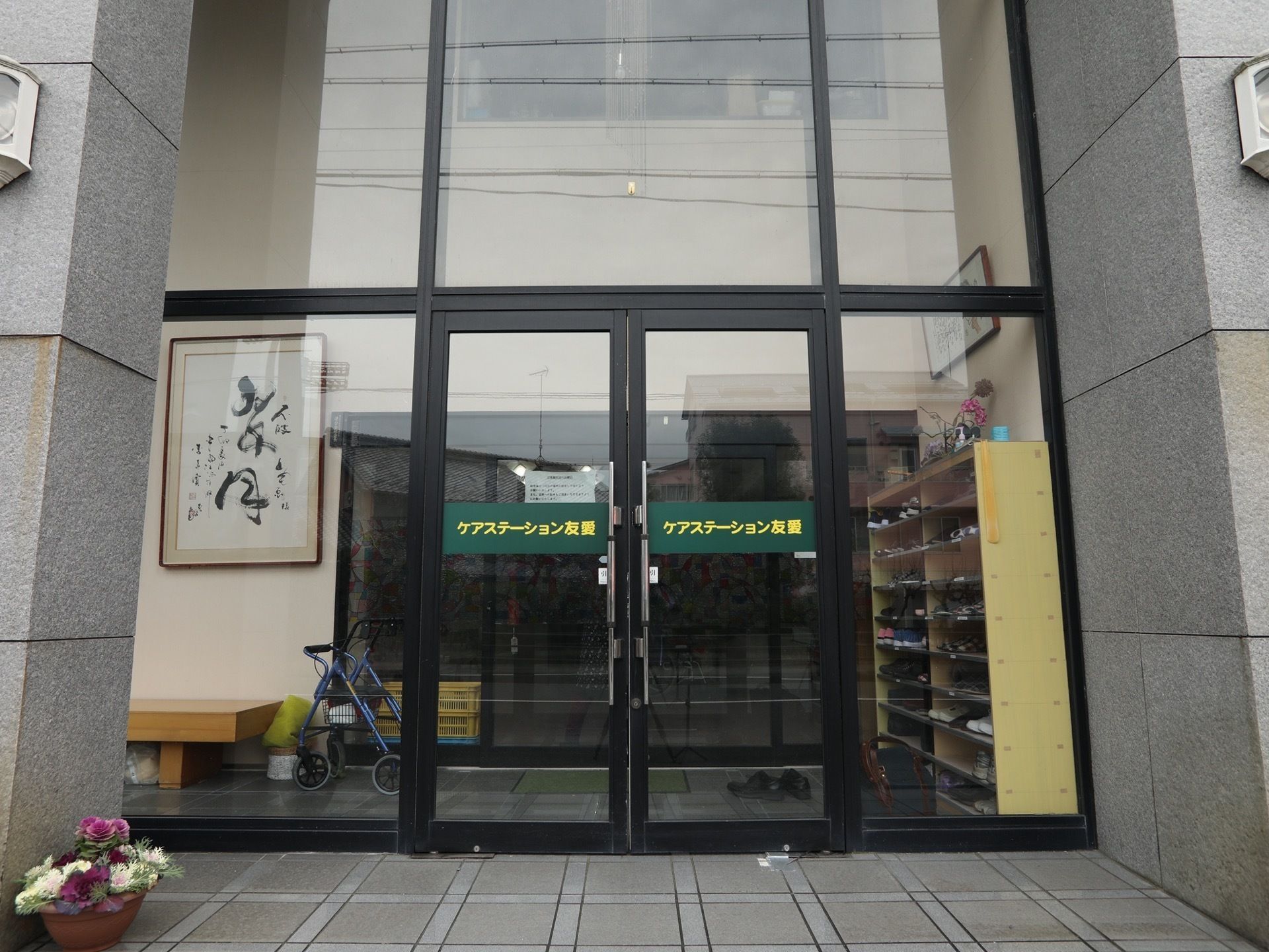玄関の扉と壁はガラスになっていて外光を室内に取込んでいる。壁には大きな下駄箱を設置している。大きなベンチもある。