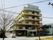 5階建ての建物は一般の賃貸物件のよう。白を基調としていてベランダもある。
