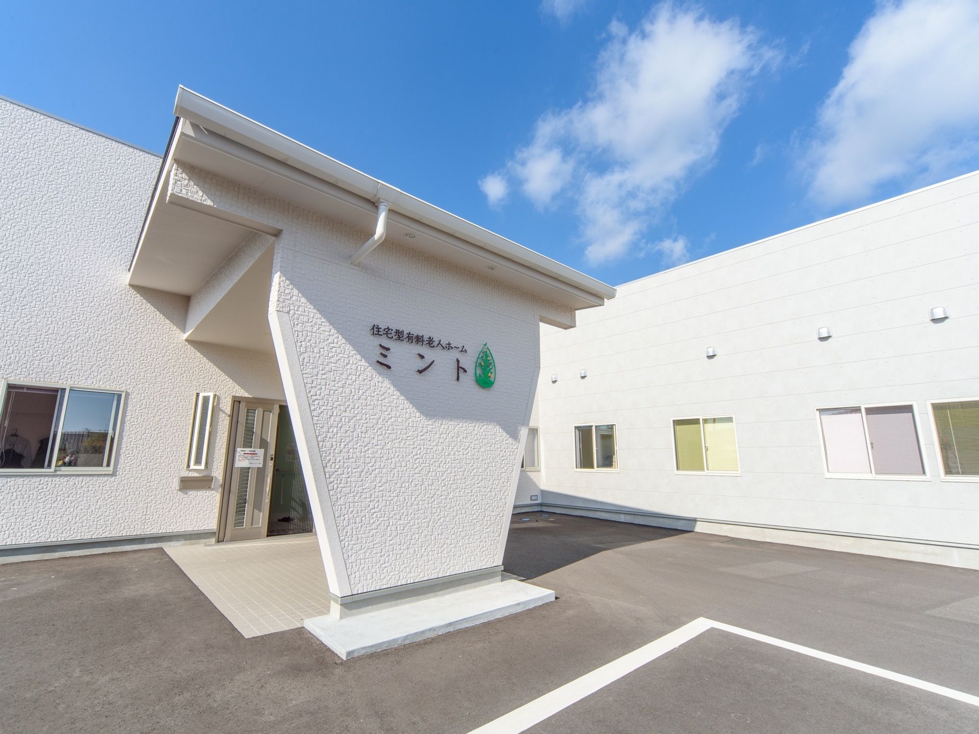 １階建ての建物で外壁は白で統一されている。中央に玄関ポーチがあり、屋根がせり出している。屋根を支える柱に施設名が書かれている。