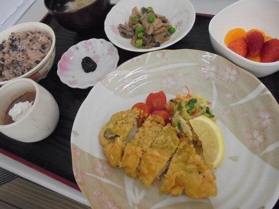 炊き込みご飯に汁物、フルーツや野菜の和え物が並び、メインはレモンが添えられたフライ。
