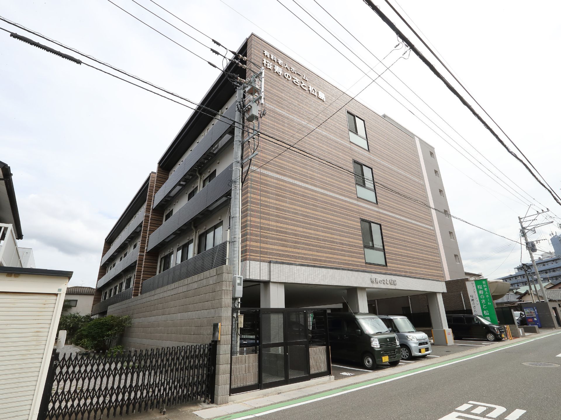 駐車場の出入り口から見た、斜め前から見た施設全体の外観