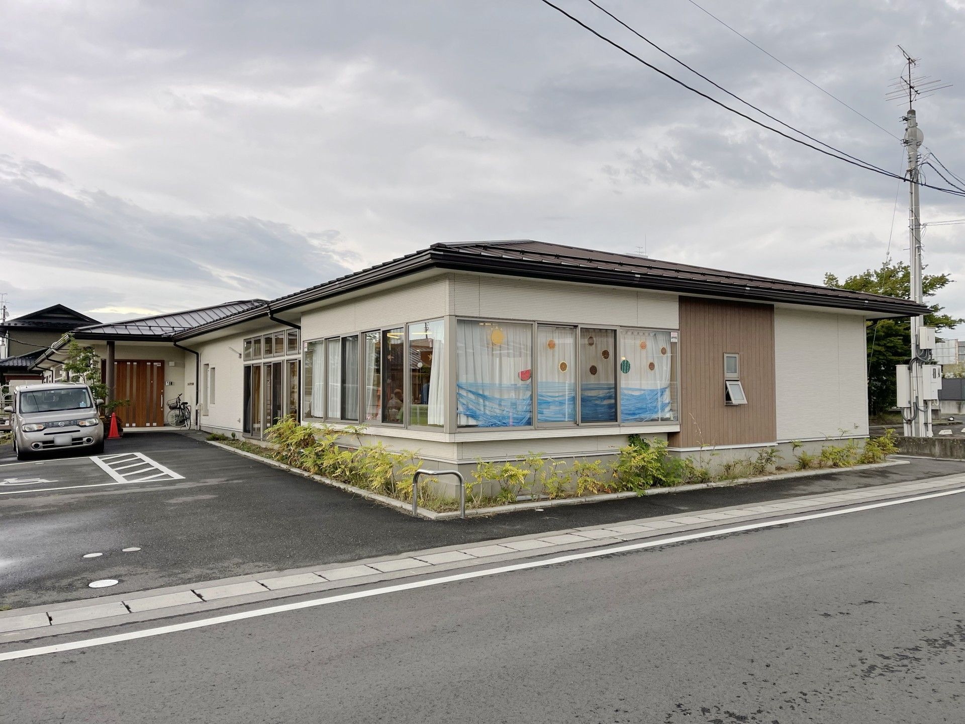 平屋建て縦の建物は道路に面し手大きな窓が設置され、中から行き交う人々を見ることができる。