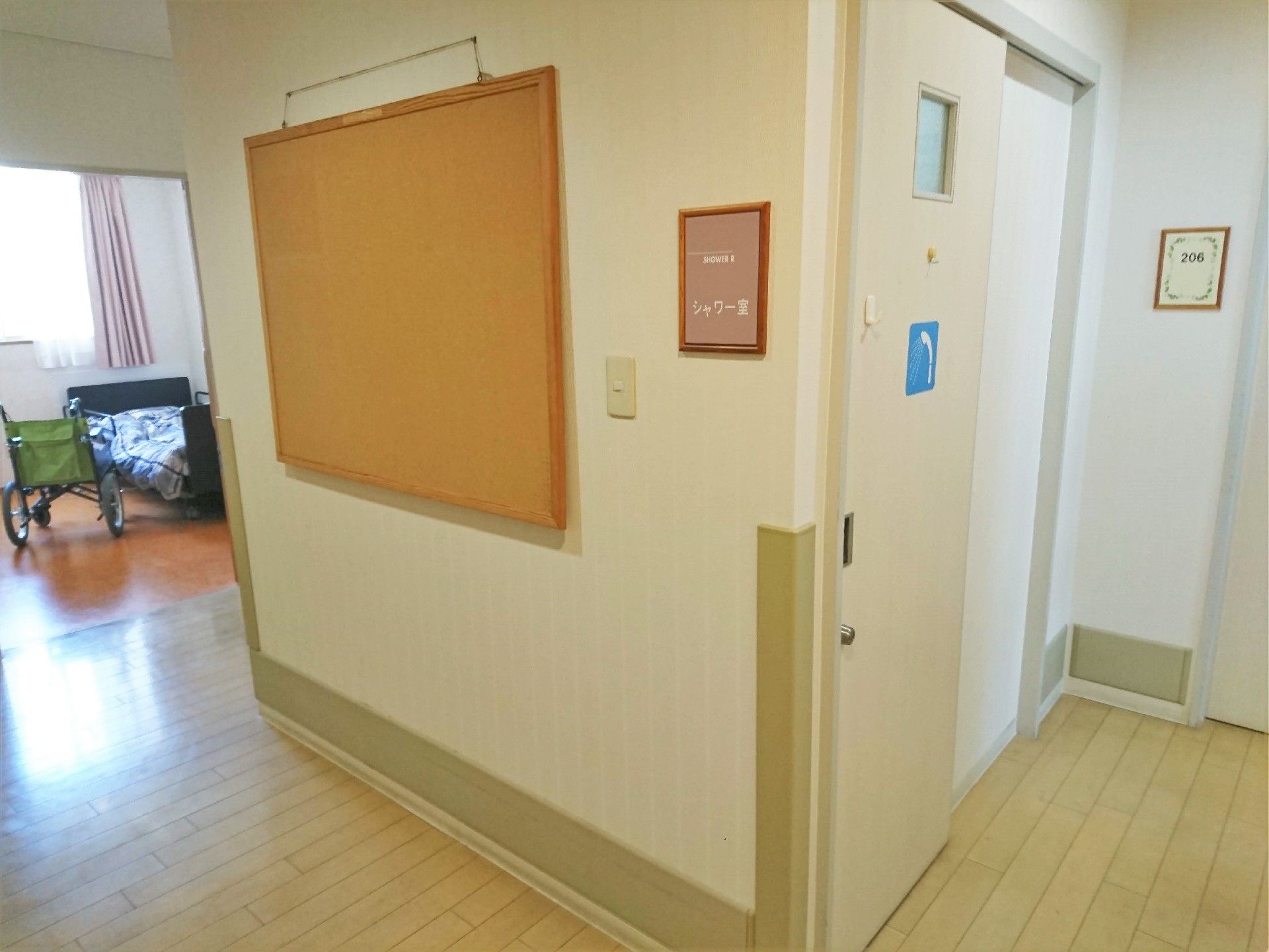 右側にはシャワー室と書かれた表札とシャワーの絵が描かれたドアがあり、左手には居室がある。