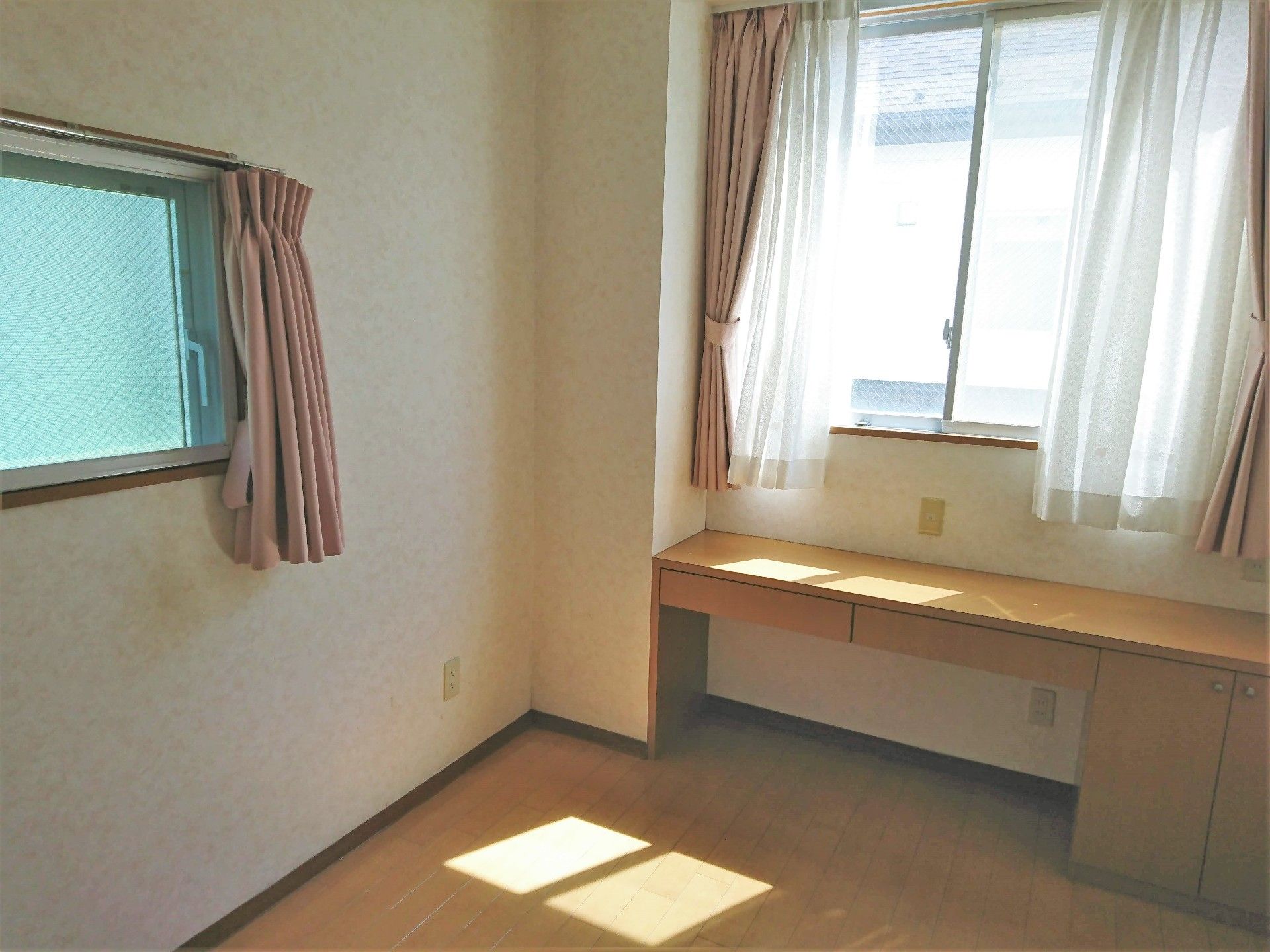 ベッドなどは置かれていないシンプルな居室。備え付けのテーブルがある。