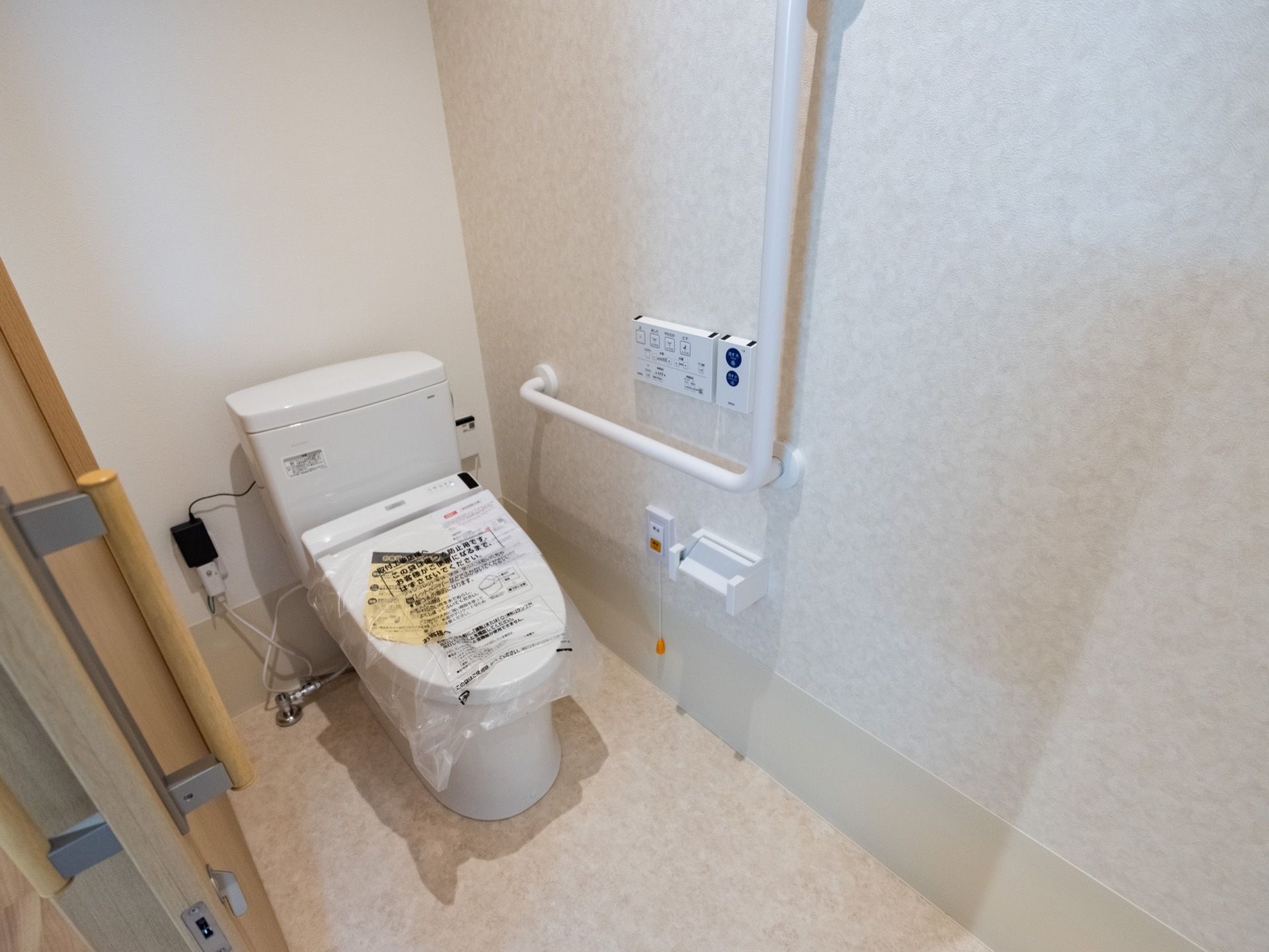 トイレは個室タイプで、扉が引き戸を採用している。便座は温水洗浄機能を完備しているので、快適に使用できる。