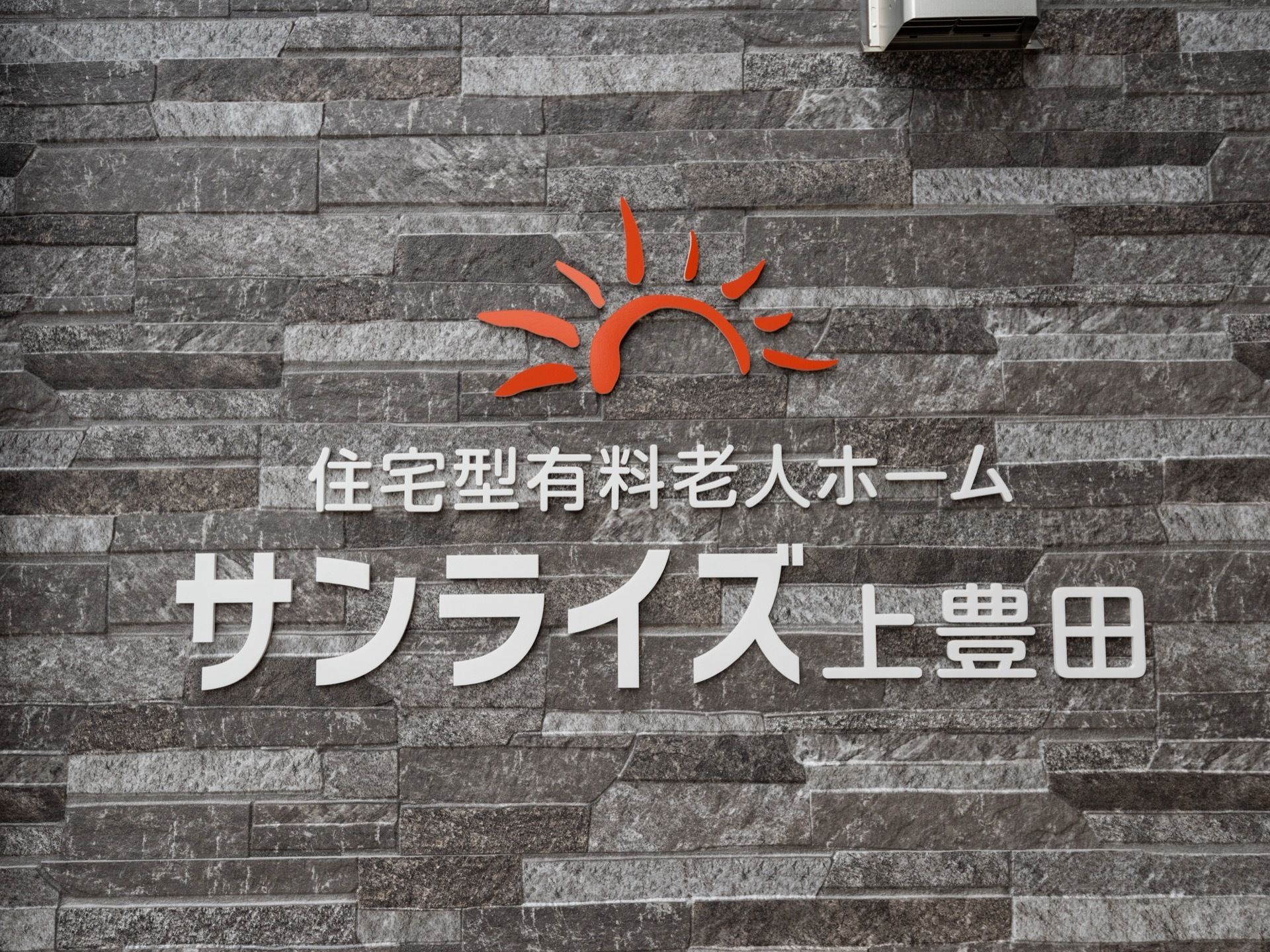 施設の名前と機能が載った看板である。日の出を表すデザインはポップで、来訪者様に親しみやすい印象を与える。